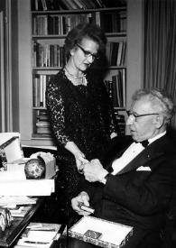 Portada:Plano general de Aniela Rubinstein, de pie, y Arthur Rubinstein, sentado,  bromeando con los eslabones de una cadena