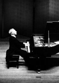Portada:Plano general de Arthur Rubinstein (perfil derecho) sentado al piano. Fotografía tomada desde el fondo de la sala de conciertos