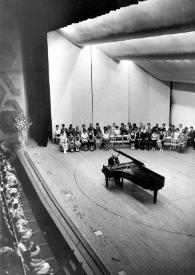 Portada:Plano general de Arthur Rubinstein (perfil derecho) sentado al piano con el público a la espalda.