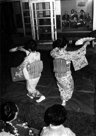 Portada:Plano general de Arthur Rubinstein, Alina Rubinstein y Aniela Rubinstein entre otros invitados (dentro de la casa) observando a dos mujeres vestidas con kimono interpretar una danza típica en el jardín de la casa.