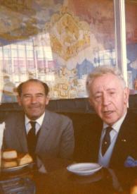 Portada:Plano medio de un hombre y Arthur Rubinstein sentados en la mesa de un restaurante.
