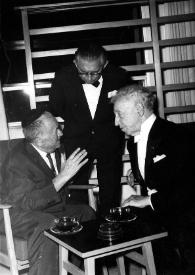 Portada:Plano medio de un hombre (perfil derecho) sentado, Henry Haftel Zvi,de pie, y Arthur Rubinstein (perfil izquierdo) sentado charlando