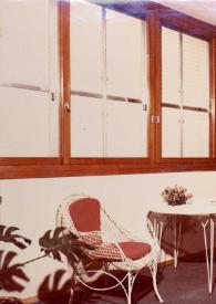 Portada:Plano general de la terraza de la Suite Rubinstein con una mesa de terraza y dos sillas, varias macetas con flores y amplios ventanales.