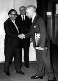 Portada:Plano general de Henry Haftel Zvi, Señor Rosen y Arthur Rubinstein con el álbum en la mano, saludandose.