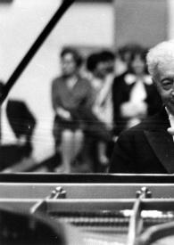 Portada:Plano medio de Arthur Rubinstein sentado al piano con el público a la espalda, levantando la mano izquierda en señal de espera. A Arthur se le ve entre la base del piano y la tapa.