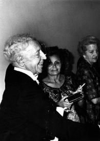Portada:Plano medio de Arthur Rubinstein (perfil derecho), una mujer, Aniela Rubinstein, una mujer y Menahem Begin (Primer Ministro de Israel) (perfil izquierdo) dando la mano a Arthur Rubinstein