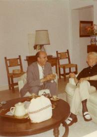 Portada:Plano general de un hombre y Arthur Rubinstein sentados en unos sillones charlando