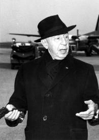 Portada:Plano medio de Arthur Rubinstein posando con sombrero y con los guantes en la mano. Al fondo aviones.