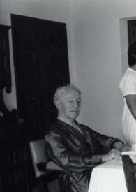 Portada:Plano general de Arthur Rubinstein posando sentado en una mesa donde Paquita y Anita charlan de pie con Aniela Rubinstein