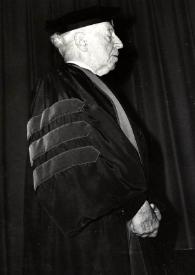 Portada:Plano general de Arthur Rubinstein (perfil derecho) posando con toga y birrete