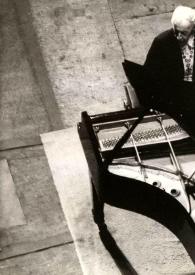 Portada:Vista aérea de Arthur Rubinstein sentado al piano con una cadena decorativa alrededor del cuello