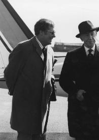 Portada:Plano medio de Arthur Rubinstein posando entre dos hombres, al fondo un avión