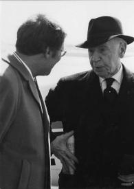 Portada:Plano medio de un hombre (medio perfil derecho) charlando con Arthur Rubinstein (medio perfil izquierdo) con sombrero