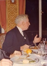 Portada:Plano medio de Arthur Rubinstein (perfil derecho) charlando sentado en una mesa