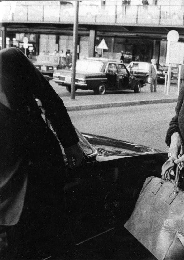 Plano general de una mujer y Arthur Rubinstein caminando hacia un coche ...