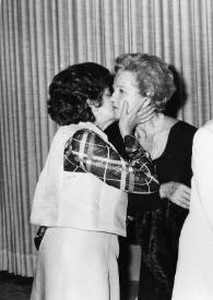 Portada:Plano general de una mujer besando a Aniela Rubinstein, Arthur Rubinstein con una caja en las manos, detrás Moshe Kol obsevando