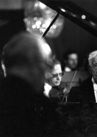 Portada:Plano medio de Arthur Rubinstein sentado al piano con la orquesta detrás. A Arthur se le ve entre la base del piano y la tapa