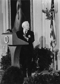 Portada:Plano general de Arthur Rubinstein hablando en el atril presidencial, Aniela Rubinstein, Betty Ford y Gerald Ford, Presidente de Estados Unidos, sentados detrás escuchándole
