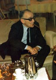 Portada:Plano general de Jacques Février (perfil derecho) y Arthur Rubinstein (perfil izquierdo) sentados en dos sofás alrededor de una mesita de café fumando un puro y charlando