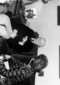 Portada:Plano general de Arthur Rubinstein y una mujer (perfil derecho) sentados en un sofá hablando