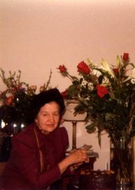 Portada:Plano medio de Aniela Rubinstein posando junto a la tarta de cumpleaños de Arthur Rubinstein y junto a un gran ramo de rosas