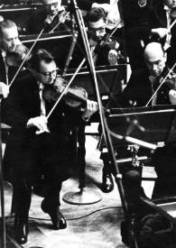 Portada:Plano medio de Arthur Rubinstein (perfil derecho) sentado al piano, detrás la orquesta