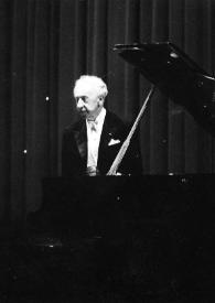 Portada:Plano general de Arthur Rubinstein de pie detrás del piano saludando al público