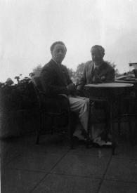 Portada:Plano general de Arthur Rubinstein y Paul Kochanski sentados en la mesa de una terraza posando
