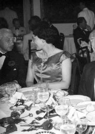 Portada:Plano general de un hombre, una mujer,  Arthur Rubinstein y una mujer charlando sentados en una mesa