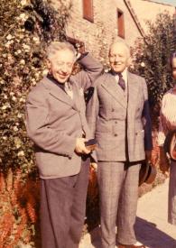 Portada:Plano general de Arthur Rubinstein posando junto a un hombre y una mujer en el jardín