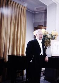 Portada:Plano general de Arthur Rubinstein (medio perfil derecho) posando de pie, apoyado en el piano