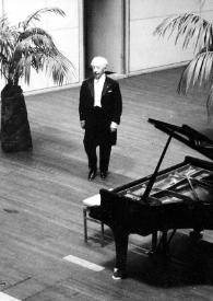 Portada:Plano general de Arthur Rubinstein de pie dirigiéndose al piano
