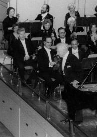 Portada:Plano general de Arthur Rubinstein (perfil izquierdo) saludando al público, al fondo la orquesta