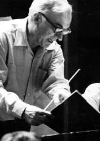 Portada:Plano medio del director de la orquesta charlando con Arthur Rubinstein mientras observan un libreto de partituras