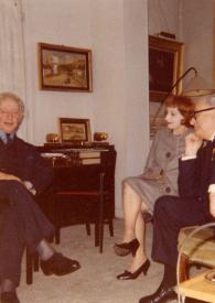 Portada:Plano general de Arthur Rubinstein, Juliette Achard y Marcel Achard posanbdo sentados y charlando