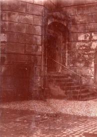 Portada:Plano general de una mujer posando en la puerta de un edificio