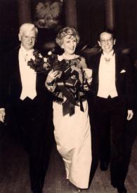 Portada:Plano general de Robert Campbell, Anita Flagler Colby con un ramo de flores en las manos y un hombre posando a la vez que caminan