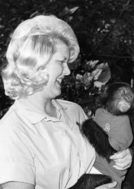 Portada:Plano medio de una mujer sujetando entre sus brazos a un mono con camiseta junto a Arthur Rubinstein charlando