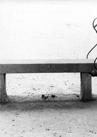 Portada:Plano general de una silla de hierro apoyada en una mesa de madera