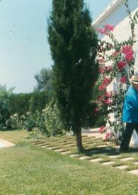 Portada:Plano general de Arthur Rubinstein (perfil derecho) caminando por el jardín hacia el estudio