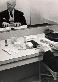 Portada:Plano medio de Arthur Rubinstein sentado en el camerino, ensayando frente a un espejo