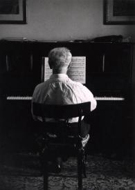 Portada:Plano general de Arthur Rubinstein de espaldas sentado al piano